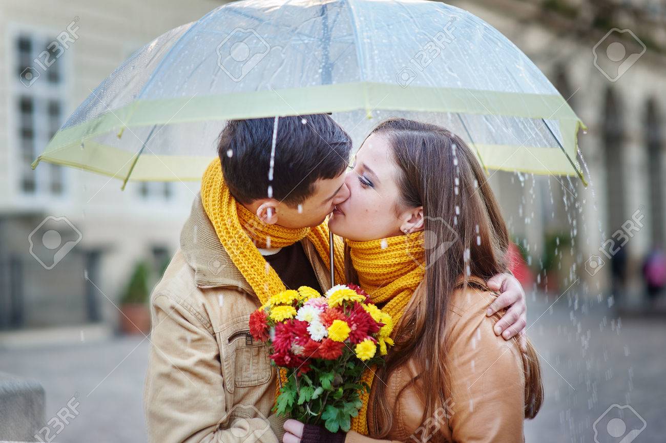 Closeup Of Young Beautiful Couple Kissing Under The Umbrella In An ...