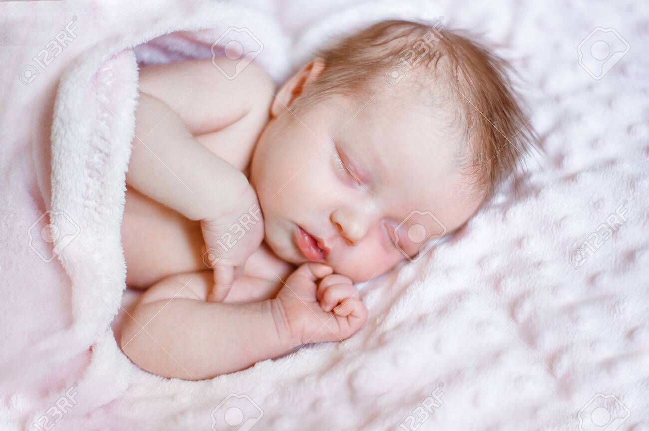 lovely newborn girl sleeping on pink blanket with place for your text - 122679771 lovely newborn girl sleeping on pink blanket with place for your text - 122679771