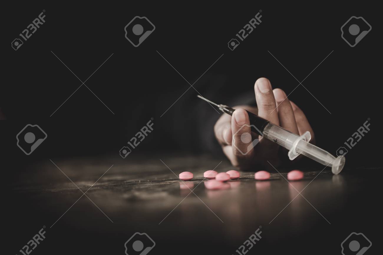 A crazed drug addict reaches for another dose of the drug in the syringe. Guy addicted, The concept of anti drugs. male drug addict, drug syringe. - 120552653 A crazed drug addict reaches for another dose of the drug in the syringe. Guy addicted, The concept of anti drugs. male drug addict, drug syringe. - 120552653