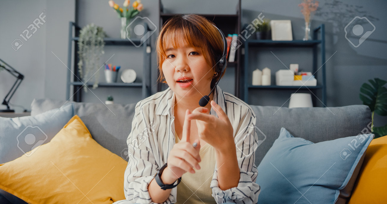 Asia businesswoman using laptop talk to colleagues about plan in video call while working from house at living room. Remotely at workplace, social distancing, quarantine for corona virus prevention. - 169422735 Asia businesswoman using laptop talk to colleagues about plan in video call while working from house at living room. Remotely at workplace, social distancing, quarantine for corona virus prevention. - 169422735