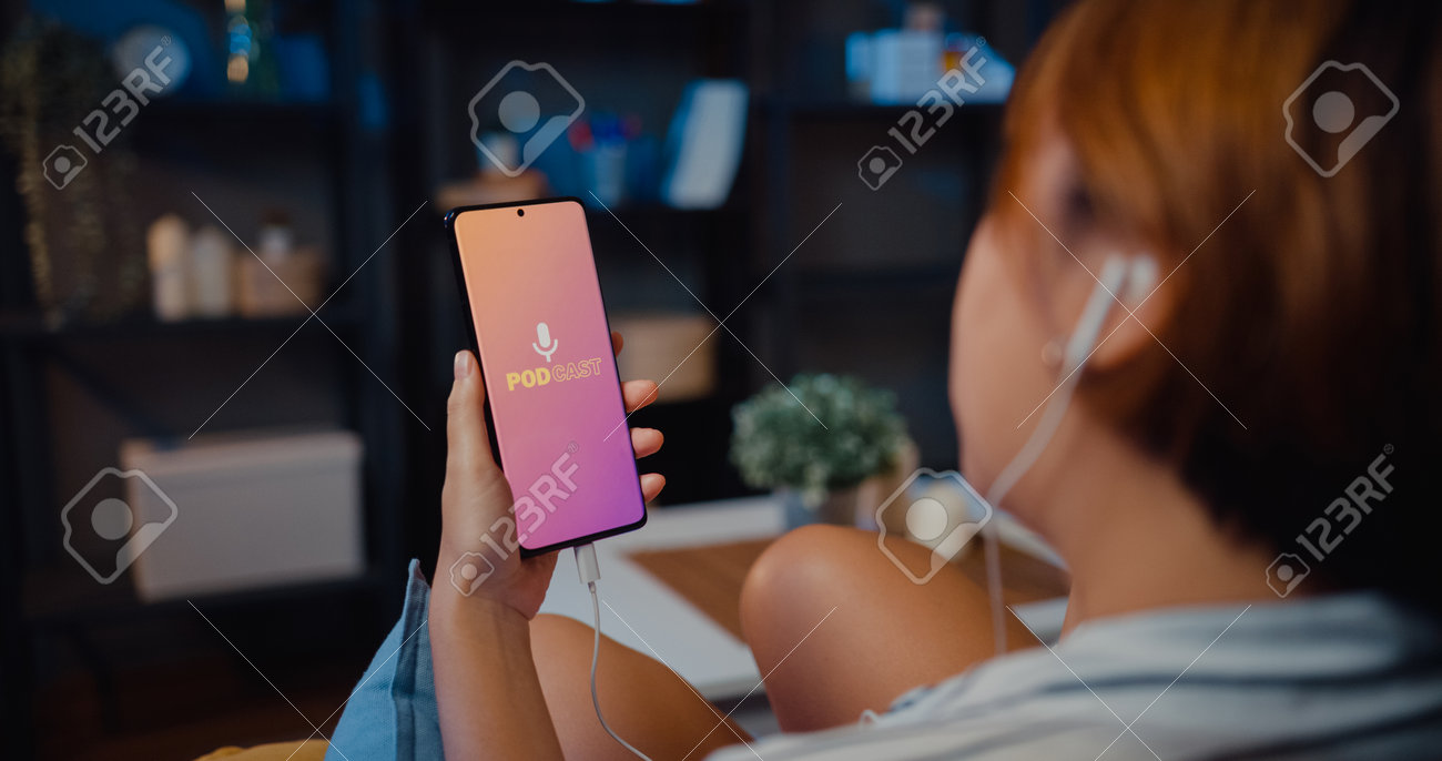 Young attractive Asia lady wear headphones using phone listen digital music podcast online channel sit on sofa in living room at house night. Social distancing, quarantine for coronavirus prevention. - 169422873 Young attractive Asia lady wear headphones using phone listen digital music podcast online channel sit on sofa in living room at house night. Social distancing, quarantine for coronavirus prevention. - 169422873