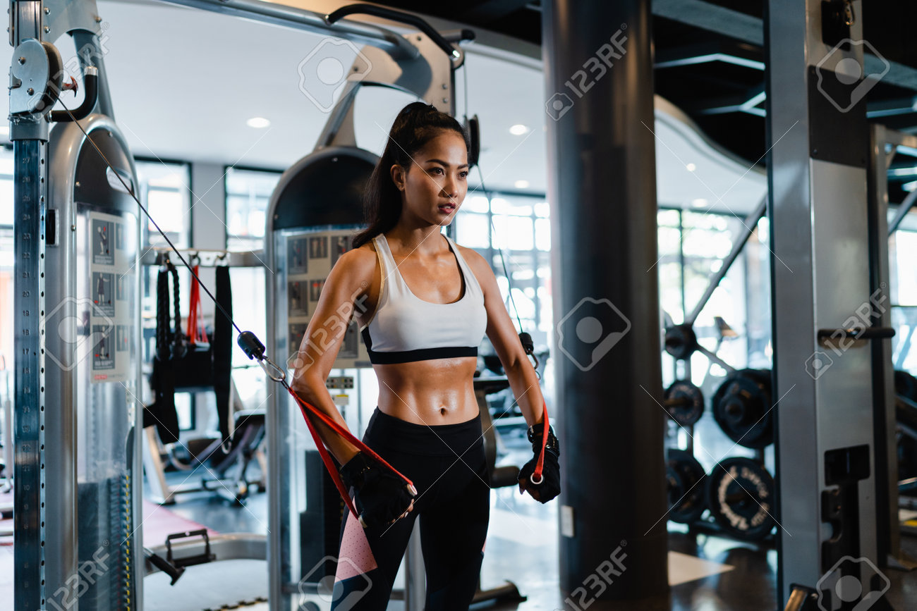 Young Asia lady exercise doing exercise-machine Cable Crossover fat burning workout in fitness class. Athlete with six pack, Sportswoman recreational activity, functional training, healthy lifestyle. - 169422984 Young Asia lady exercise doing exercise-machine Cable Crossover fat burning workout in fitness class. Athlete with six pack, Sportswoman recreational activity, functional training, healthy lifestyle. - 169422984