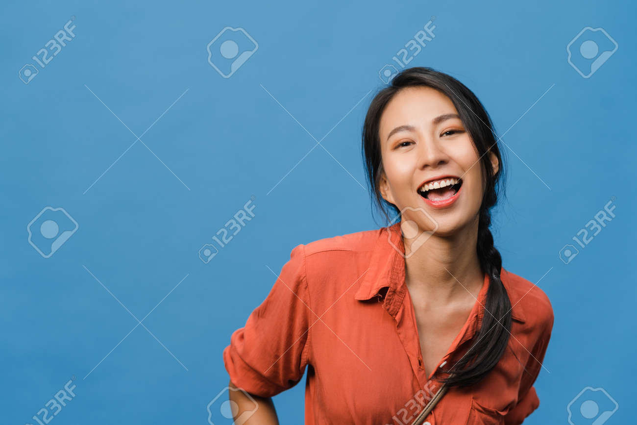 Young Asia Lady With Positive Expression, Smile Broadly, Dressed In Casual  Clothing And Looking At Camera Over Blue Background. Happy Adorable Glad  Woman Rejoices Success. Facial Expression Concept. Stock Photo, Picture and