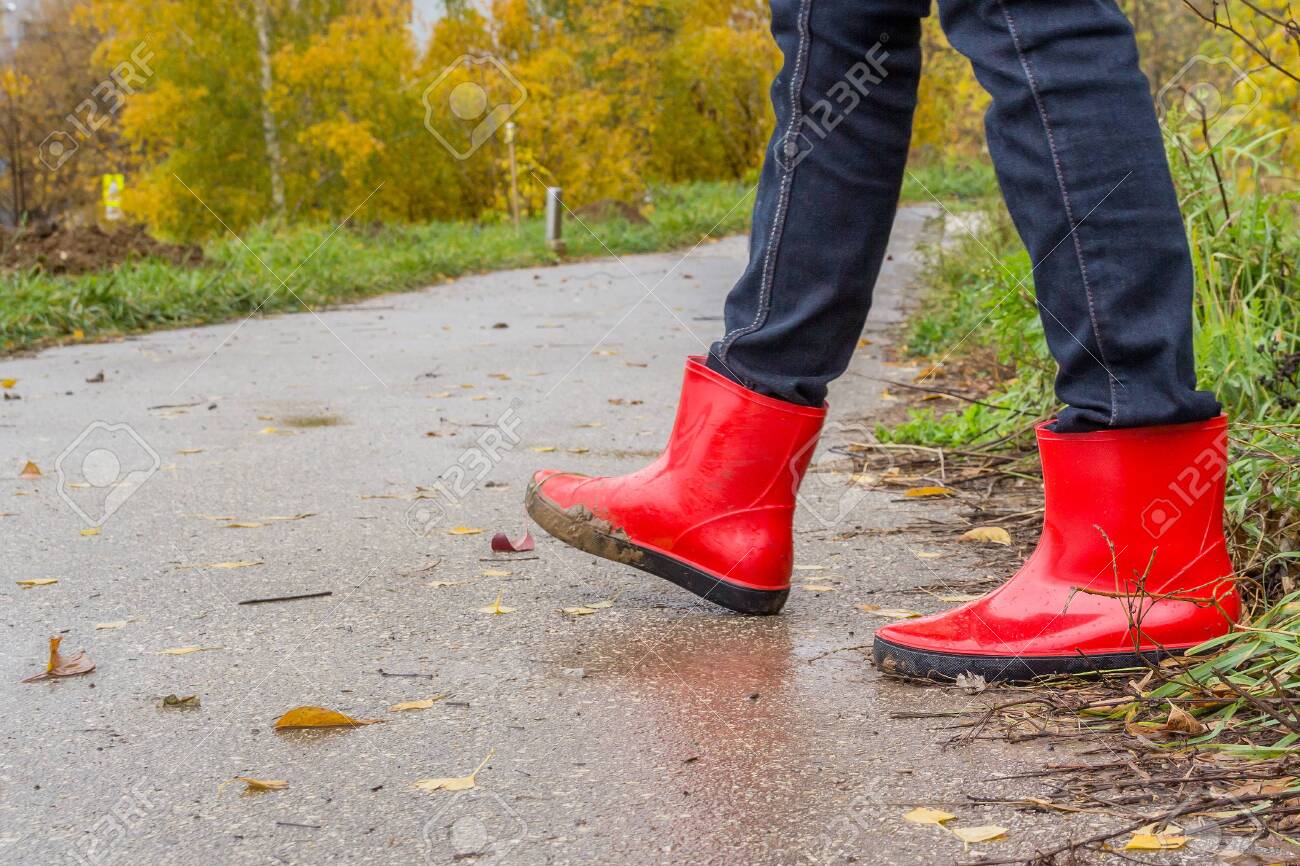 Walking in red rubber boots in the fall - 143044720 Walking in red rubber boots in the fall - 143044720