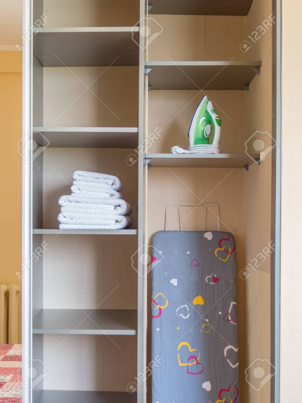 Ironing board, iron, clean towels at closet - 144347315 Ironing board, iron, clean towels at closet - 144347315