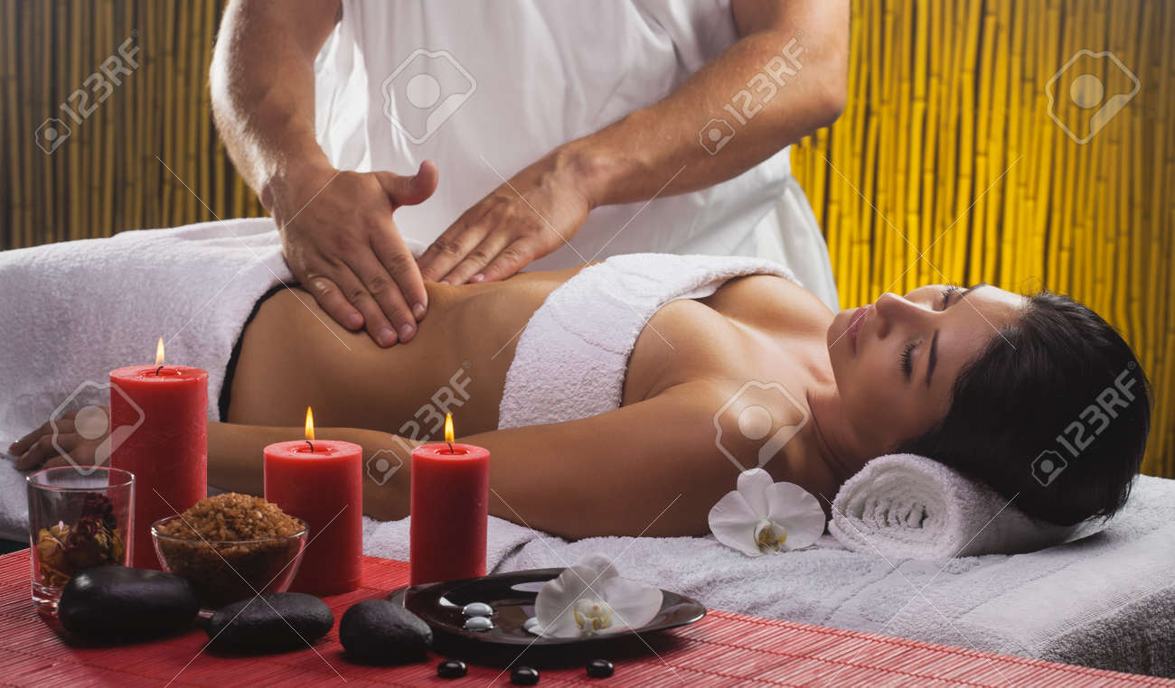 Beautiful Brunette In A Massage Parlor. Spa With Candles And Orchids Stock  Photo, Picture and Royalty Free Image. Image 182827919.