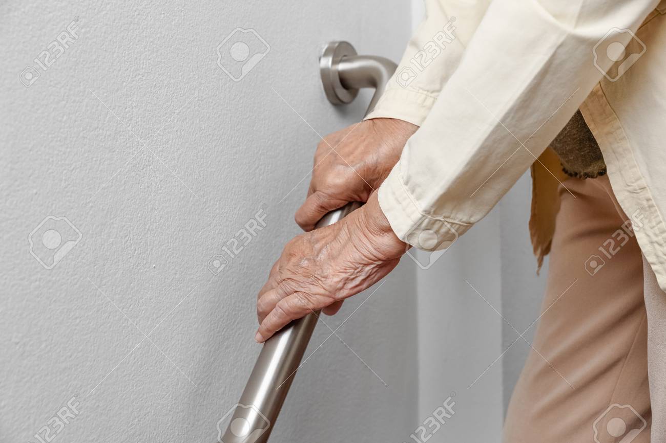Elderly woman holding on handrail for safety walk steps - 103855986 Elderly woman holding on handrail for safety walk steps - 103855986