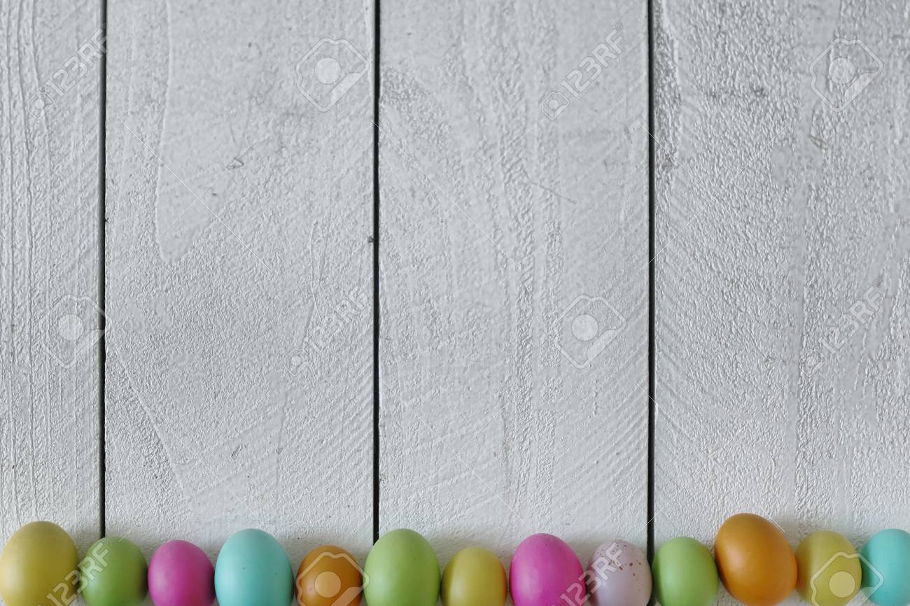 spring or easter themed background of old wood and colored eggs