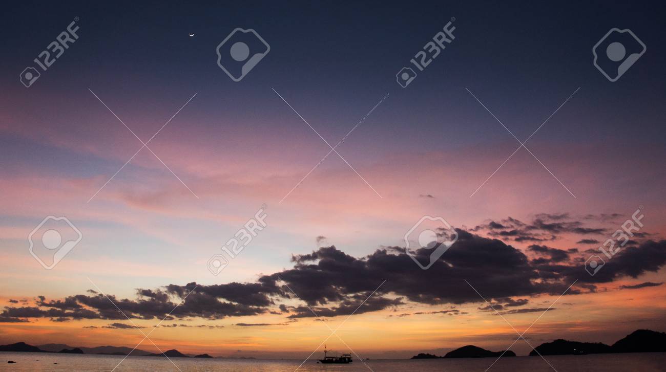 地平線 ラブアン島バホ バジャワ夕暮れオレンジ紫紫青着色された夕焼け空と海を横断船のシルエット の写真素材 画像素材 Image