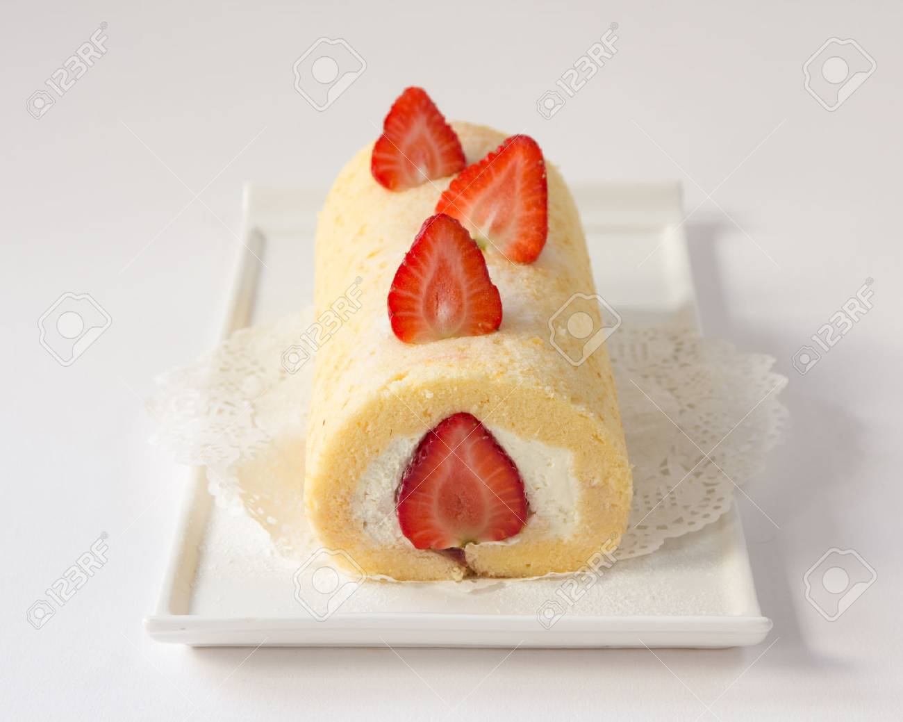 ロールケーキと 白い皿の上のイチゴをトッピング の写真素材 画像素材 Image