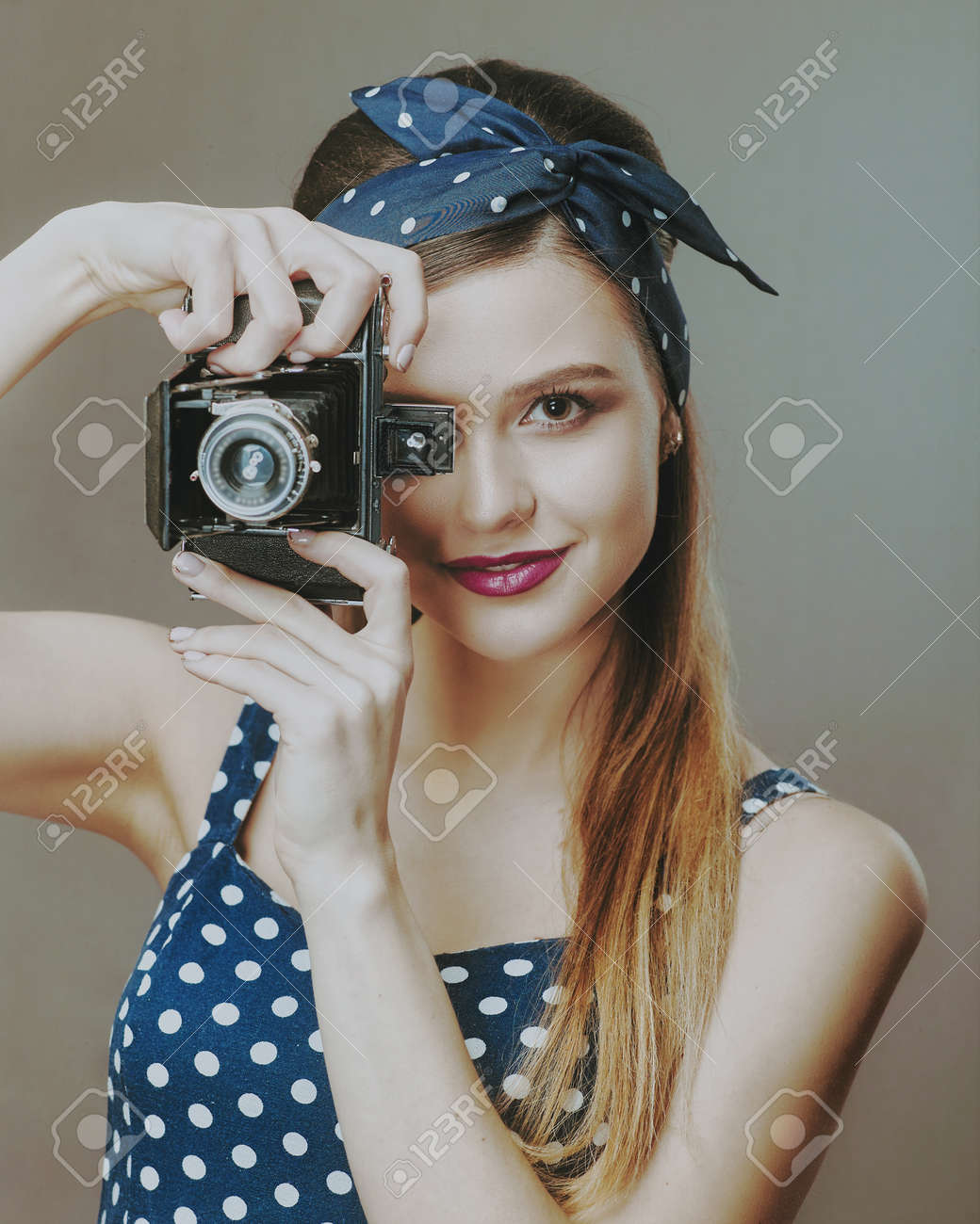 Photographer. Female Pinup Portrait. Young adult woman posing with vintage photo camera - 159316742 Photographer. Female Pinup Portrait. Young adult woman posing with vintage photo camera - 159316742