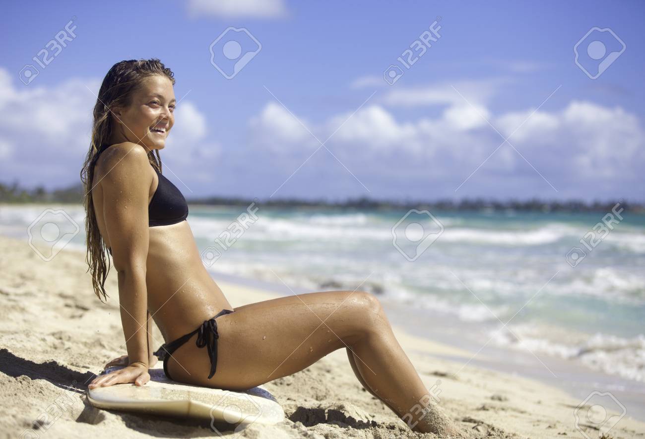 ハワイのビーチで彼女のサーフボードの上に座ってビキニ ブロンドの女の子 の写真素材 画像素材 Image