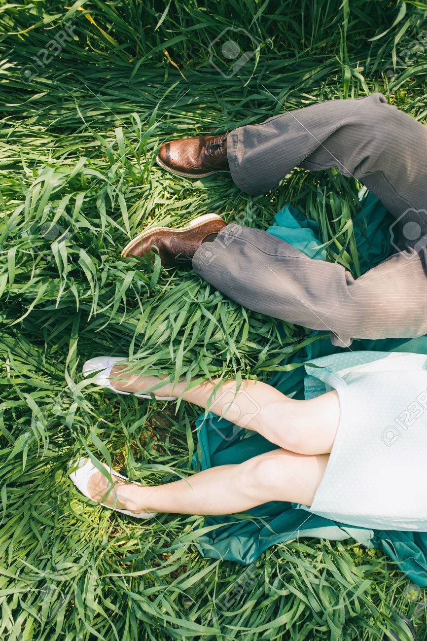 高い草 トップの視点でカップルを敷設脚だけ 婚約写真 結婚式 ピクニック 晴れた日 ターコイズのドレス ヴィンテージ色で乙女の顔なしのロマンチックな写真の前に の写真素材 画像素材 Image
