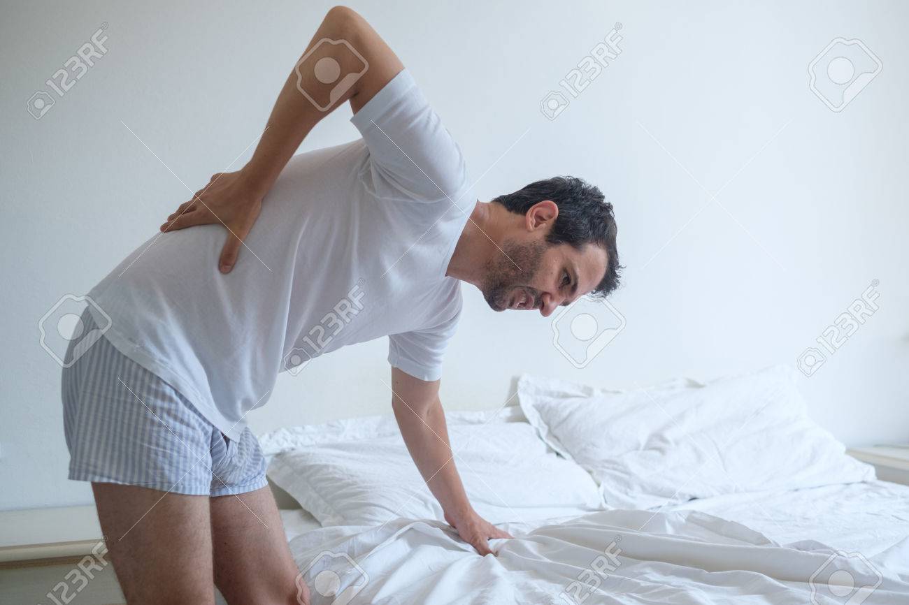 Man Fühlt Rückenschmerzen Im Bett Nach Dem Schlafen Lizenzfreie ... Man Fühlt Rückenschmerzen Im Bett Nach Dem Schlafen Lizenzfreie ...
