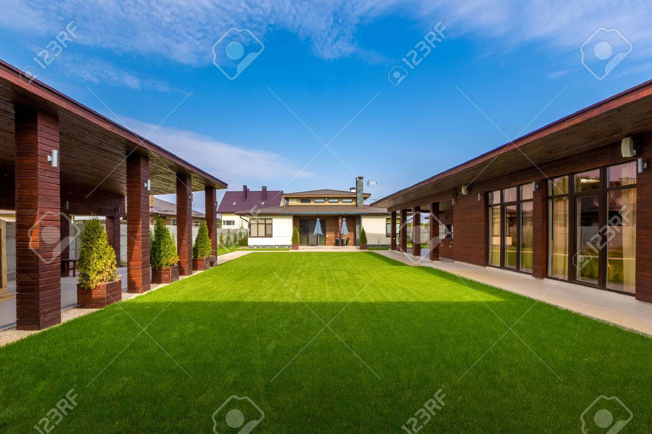 美しいモダンな木造住宅はステンド グラスの窓 緑の芝生からの眺めです の写真素材 画像素材 Image