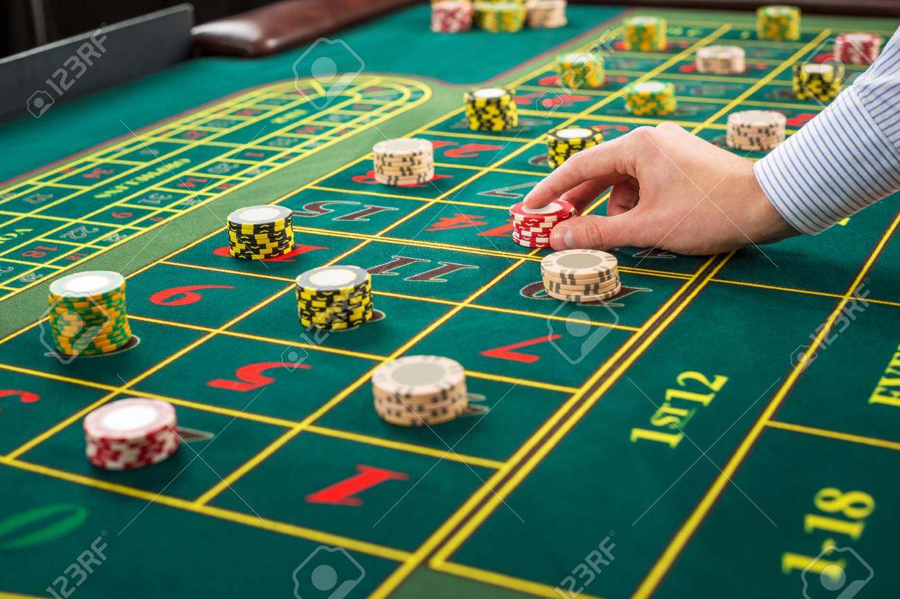 Picture Of A Green Table And Betting With Chips Man Hand Over Casino Chips On Roulette Table Close Up Stock Photo Picture And Royalty Free Image Image 53162659