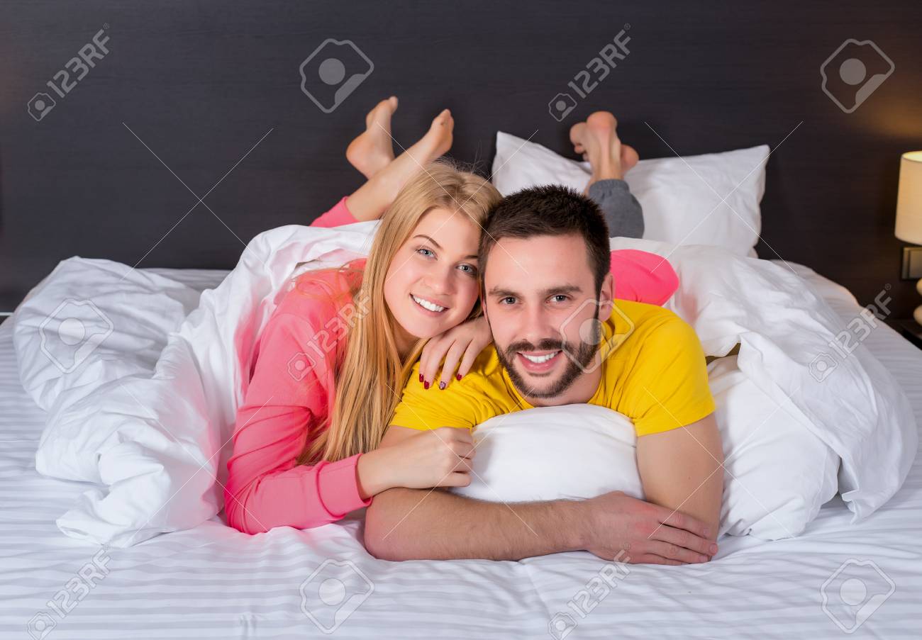Young Lovely Couple Lying And Have Fun In A Bed Happy Smile