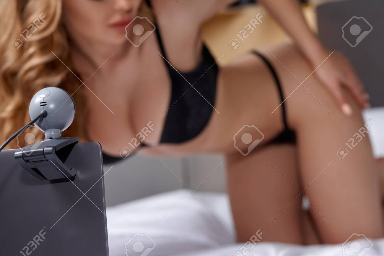 128625625-beautiful-young-girl-posing-in-front-of-a-web-camera-working-as-a-model-he-takes-off-his-bra-the.jpg