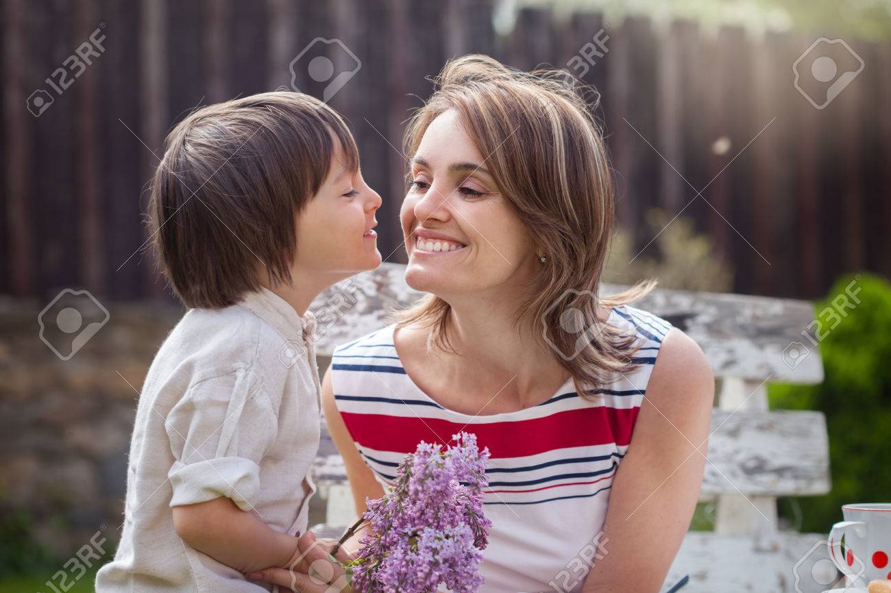 Belle Maman Un Café Dans Une Arrière Cour Jeune Enfant Mignon Donnant Son Présent Et De Fleurs Pour Son Anniversaire Mère Concept De Jour Amour