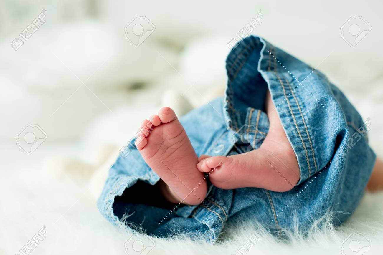 little baby boy feet baby lie down in bed in the afternoon stock