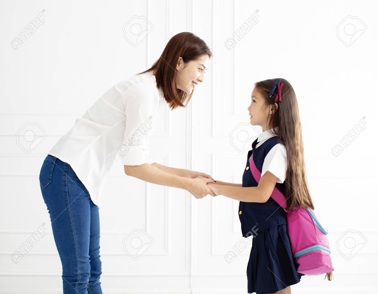 Mother holding hand of daughter ready go to school - 102387740 Mother holding hand of daughter ready go to school - 102387740
