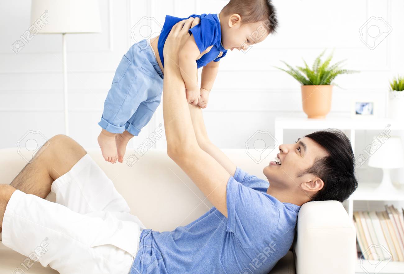 Father And Son Playing On Sofa - 104293291 Father And Son Playing On Sofa - 104293291