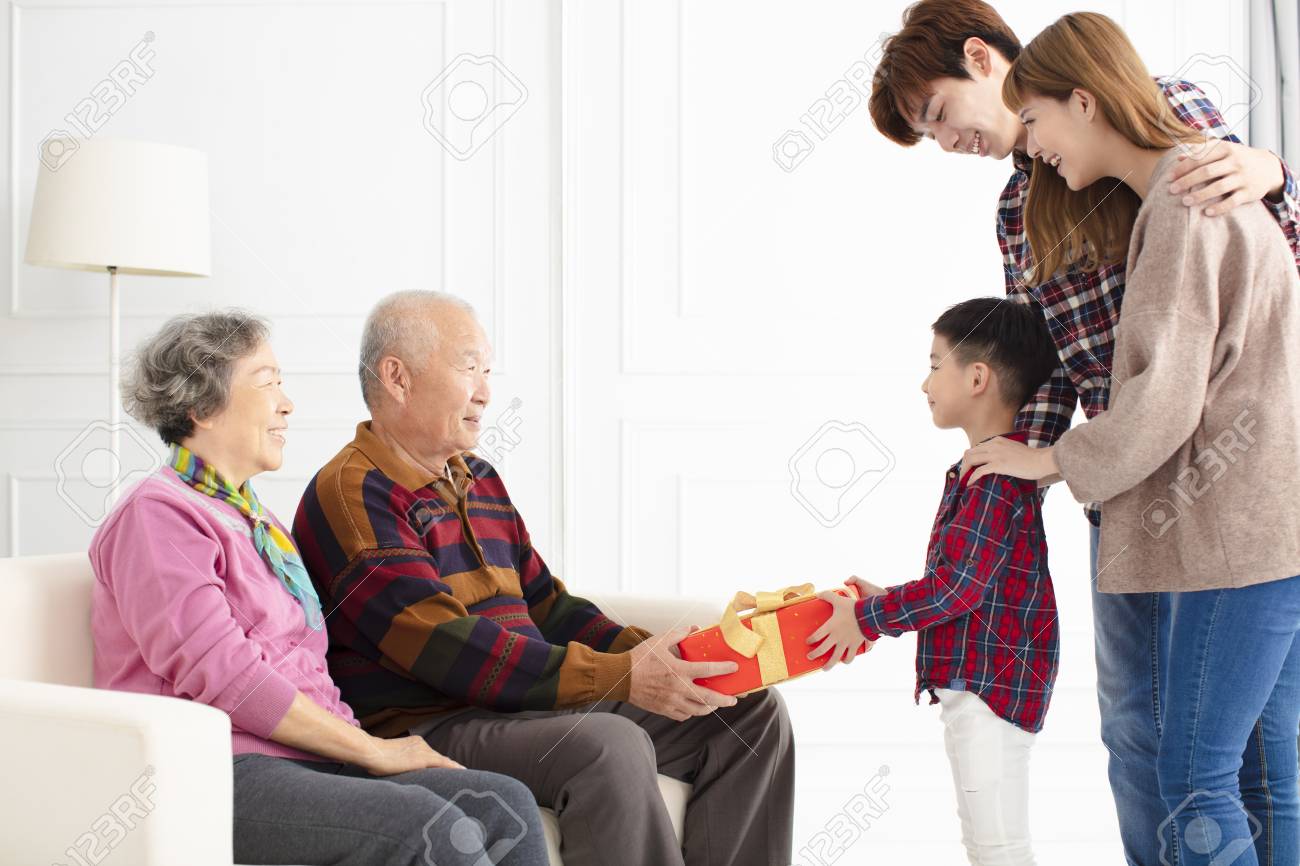 grandchild with parents giving a gift to grandparents - 115369852 grandchild with parents giving a gift to grandparents - 115369852