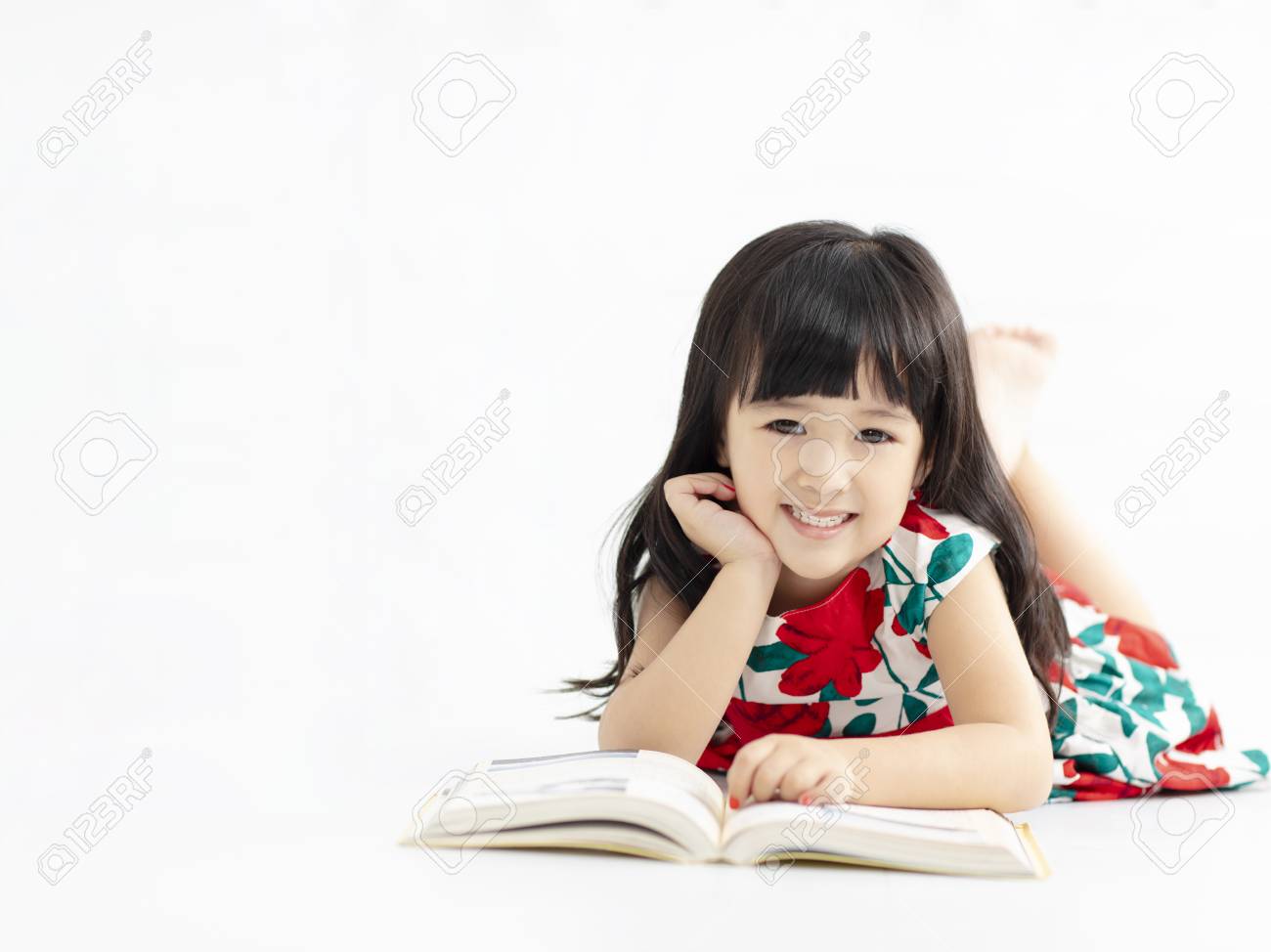 smiling little girl with book lying on the floor - 115661040 smiling little girl with book lying on the floor - 115661040