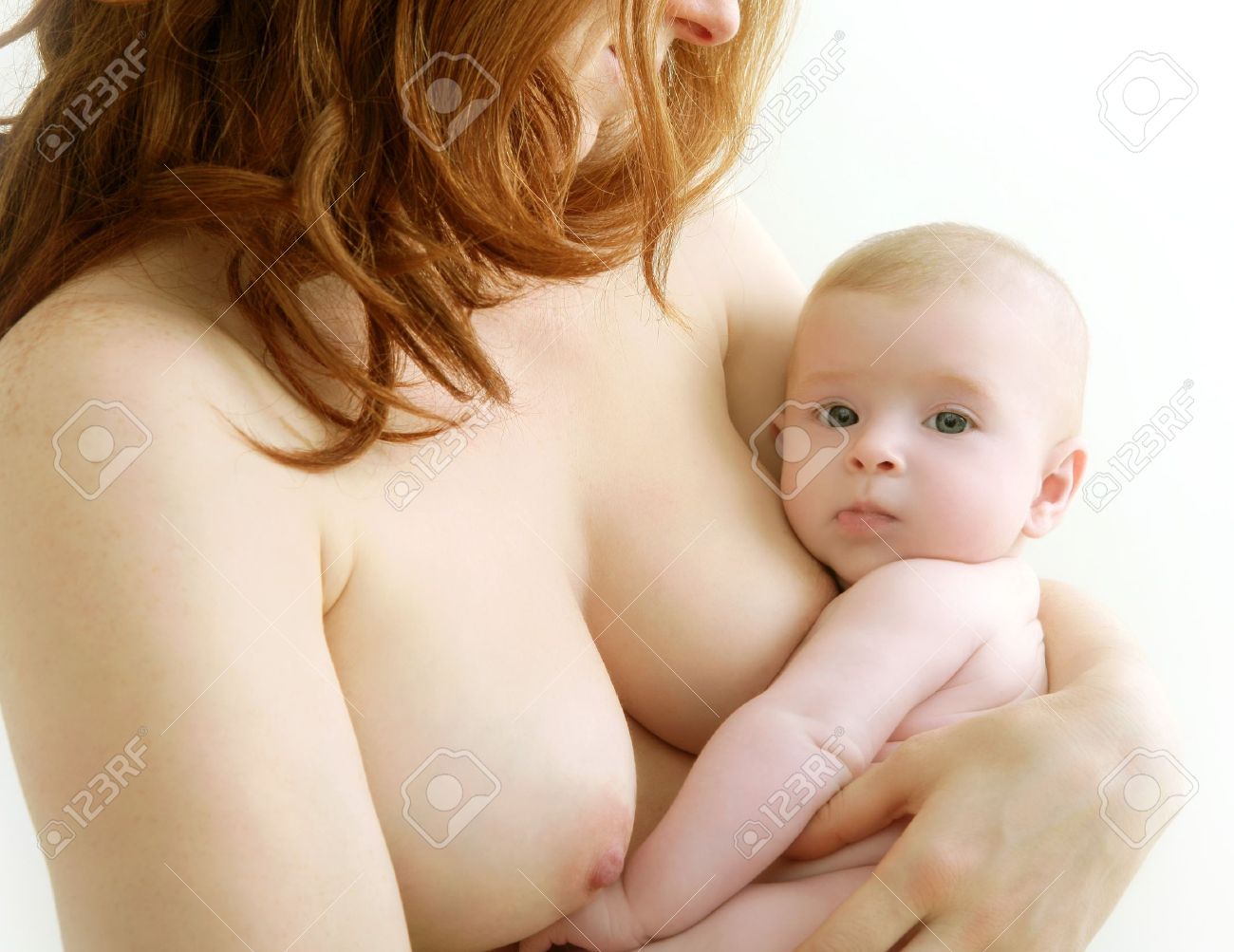 mother holding nude baby in arms on her breast - 6985503.