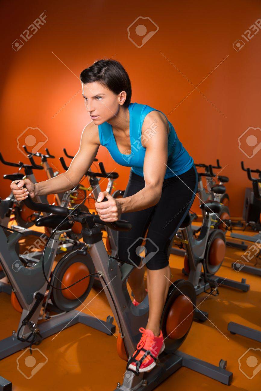 オレンジ色の自転車のジムでエアロビクス回転女性運動トレーニング の写真素材 画像素材 Image