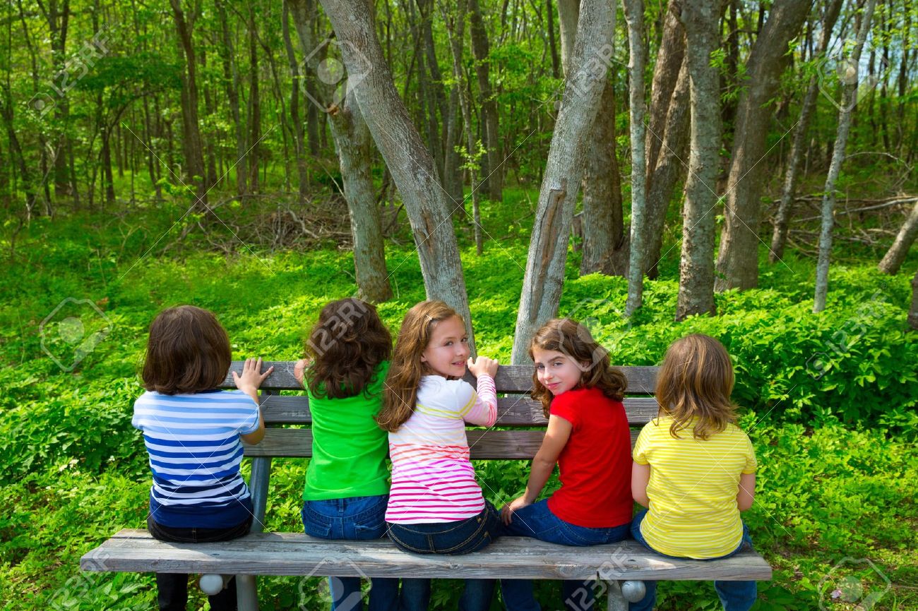 Children sister and friend girls sitting on park bench looking at forest and smiling - 20098552 Children sister and friend girls sitting on park bench looking at forest and smiling - 20098552