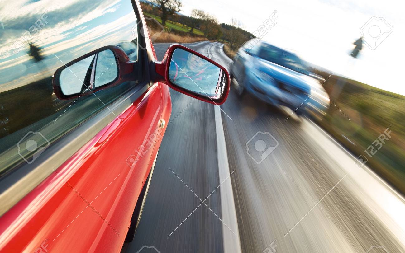 対向車に向かって赤い車を運転する男 の写真素材 画像素材 Image