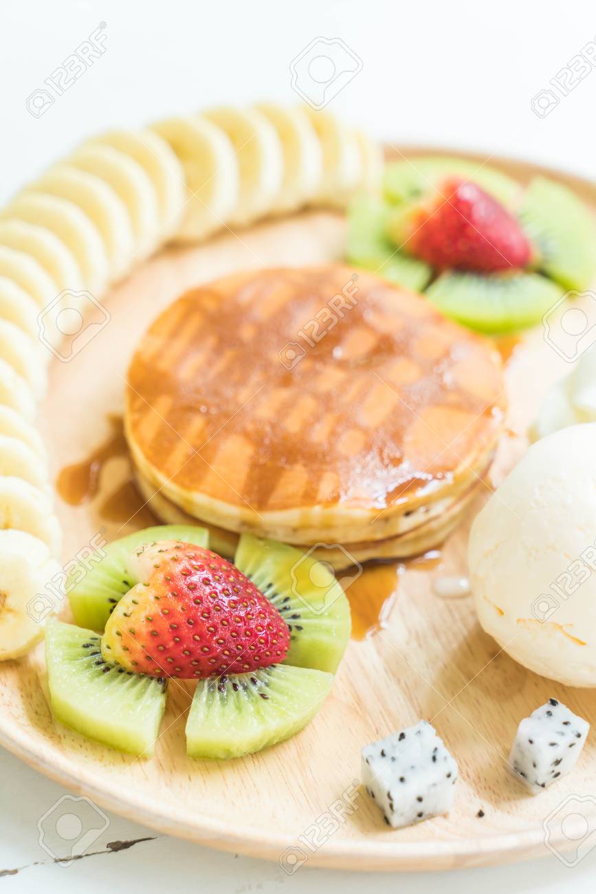 バニラのアイスクリーム ホイップ クリーム バナナ キウイ イチゴ ドラゴン フルーツ 蜂蜜のパンケーキします の写真素材 画像素材 Image