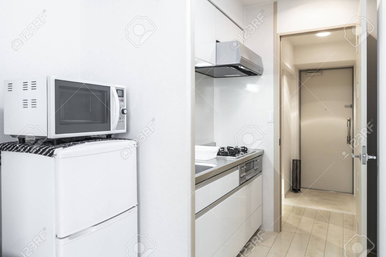 Microwave And Refrigerator Placed Next To The Kitchen Cabinet
