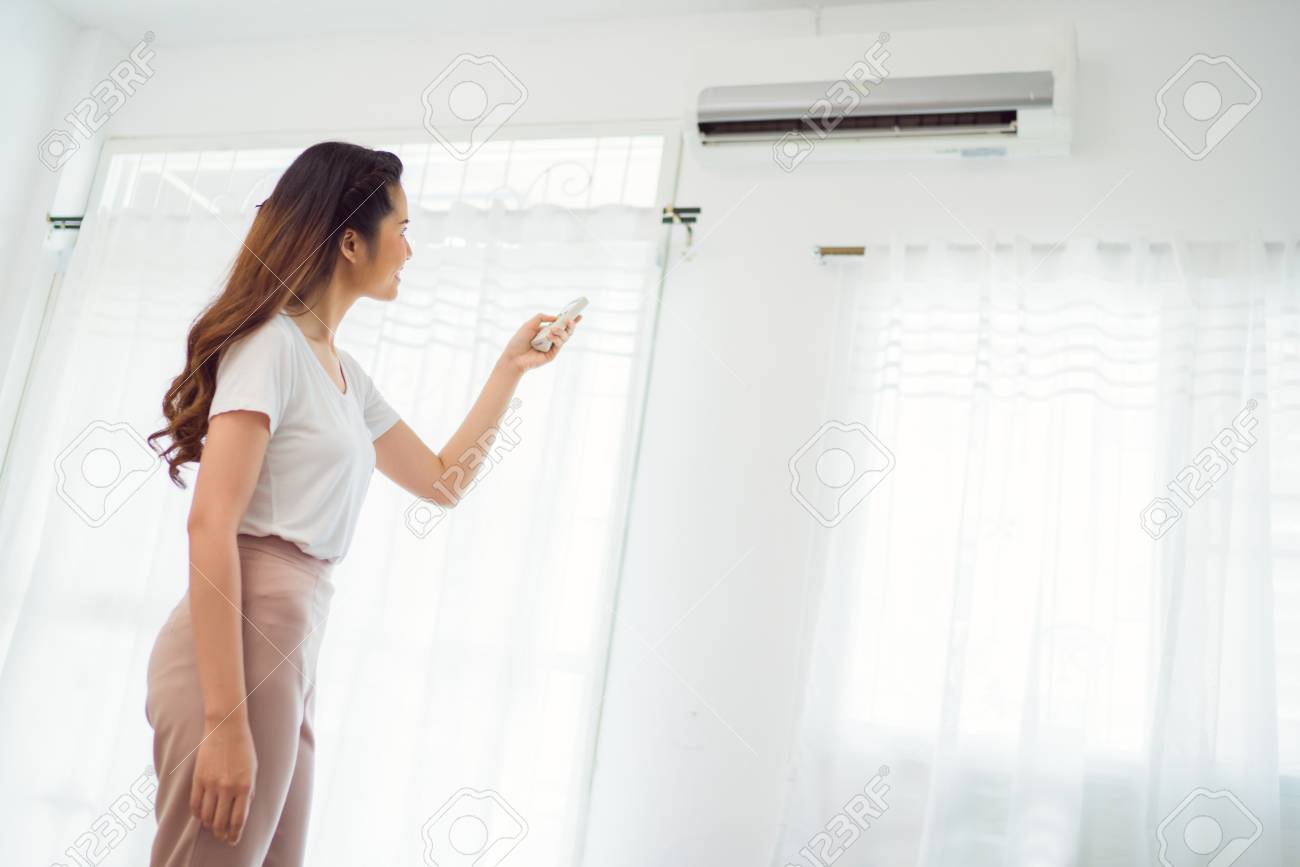 Asiatische Frau Die Fernbedienung Klimaanlage Im Haus Halt