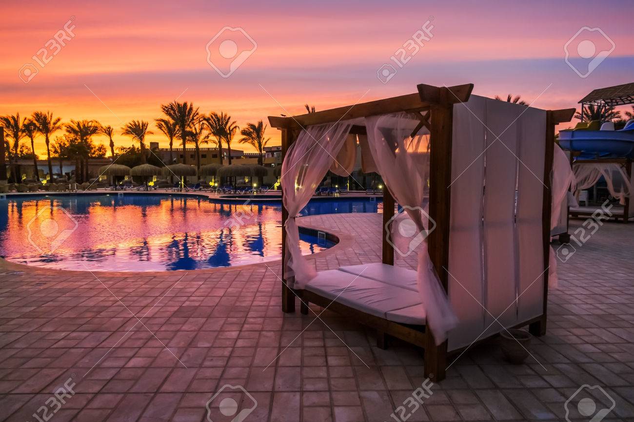 夕暮れ時のビーチでプールで天蓋付きビーチ ベッド の写真素材 画像素材 Image