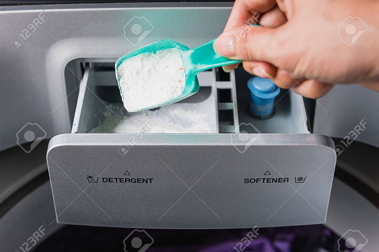 man hand pouring washing powder into the washing machine - 55509566 man hand pouring washing powder into the washing machine - 55509566