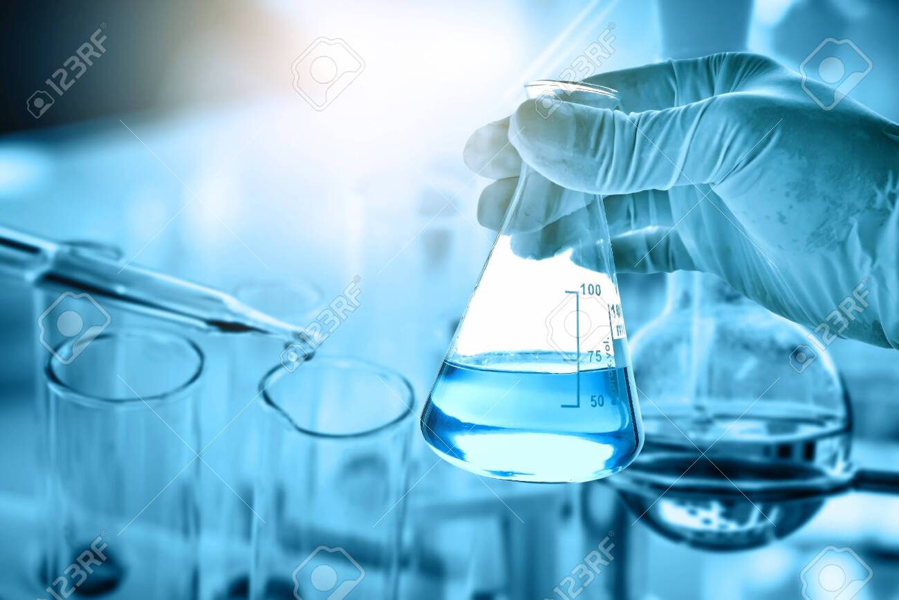 hand of scientist holding flask with lab glassware in chemical laboratory background, science laboratory research and development concept - 149708616 hand of scientist holding flask with lab glassware in chemical laboratory background, science laboratory research and development concept - 149708616
