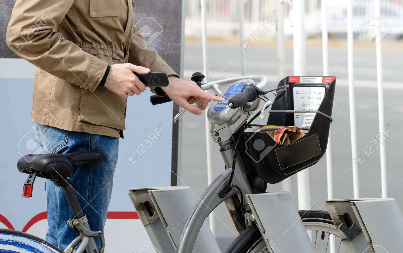 Man taking a bicycle in a bike sharing city service - 77651871 Man taking a bicycle in a bike sharing city service - 77651871