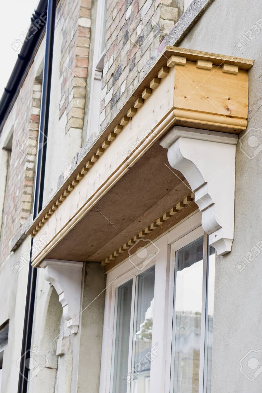 Una nuova tettoia in legno sopra la finestra di una casa di città ... Finestra in inglese