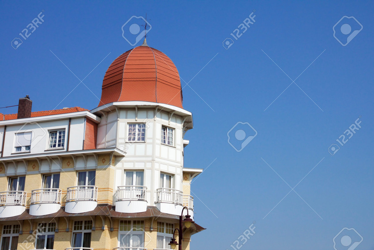 Historical architecture in De Haan, Belgium in Belle Epoque style with an interesting red roofed townhouse with corner octagonal turrets and wrought iron balconies against a blue sky - 78728747 Historical architecture in De Haan, Belgium in Belle Epoque style with an interesting red roofed townhouse with corner octagonal turrets and wrought iron balconies against a blue sky - 78728747