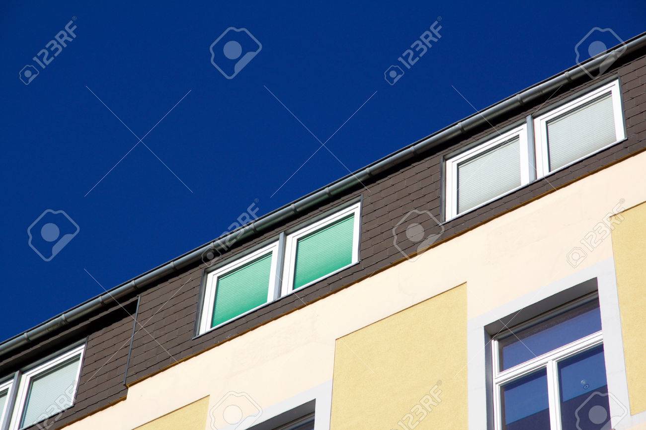 Facade of a yellow house with windows with closed shutters in different colors. Against a blue sky with copyspace. Aachen, Germany - 78753702 Facade of a yellow house with windows with closed shutters in different colors. Against a blue sky with copyspace. Aachen, Germany - 78753702