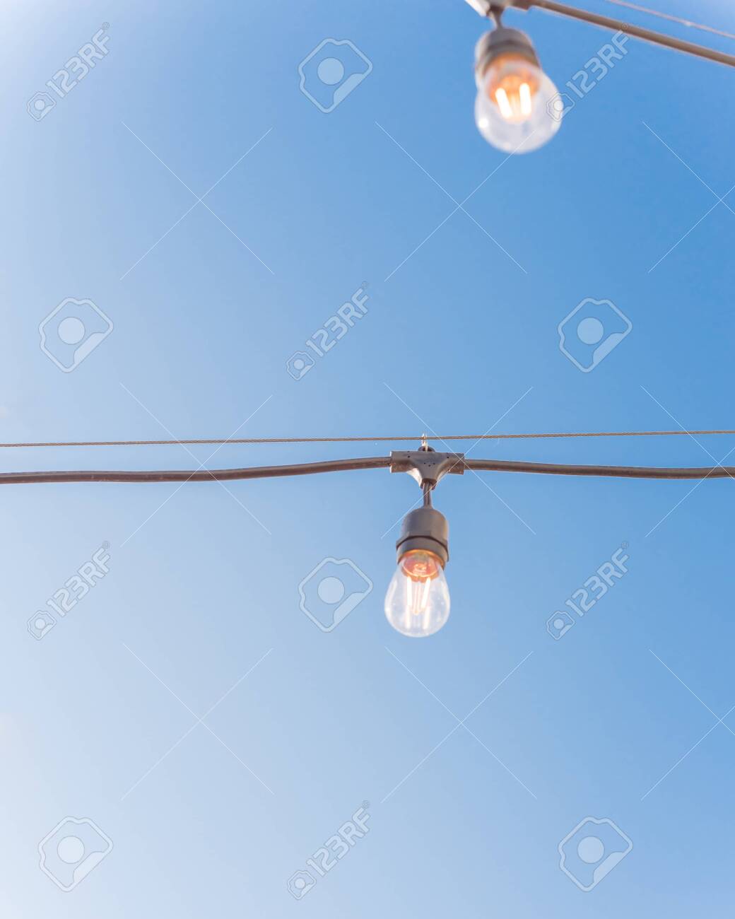 Close Up String Wired Bulbs On Clear Blue Sky Background Illuminated Stock Photo Picture And Royalty Free Image Image 142408113