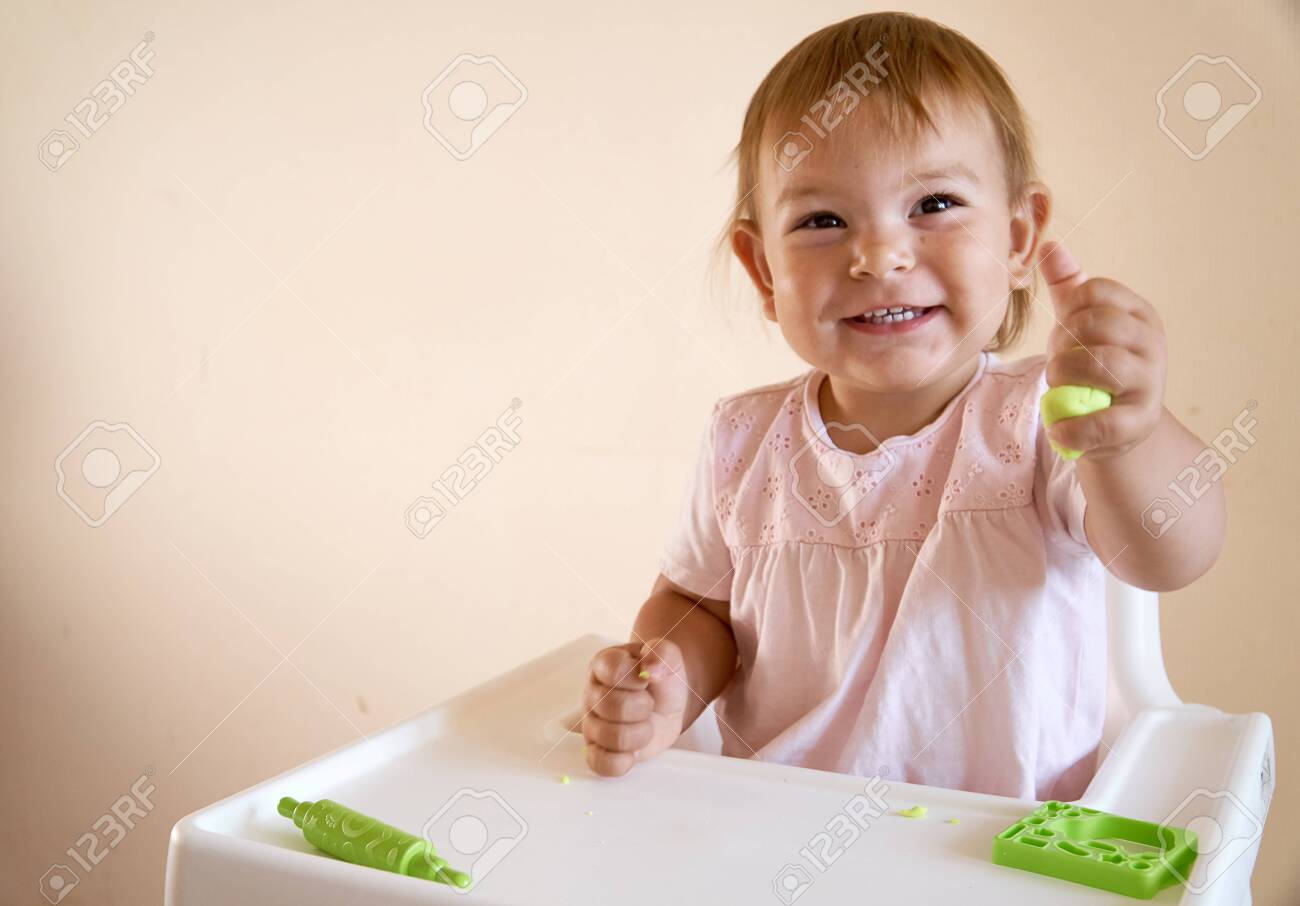 Little child engaged in playdough modeling at table, copy space. lifestyle - 128256334 Little child engaged in playdough modeling at table, copy space. lifestyle - 128256334