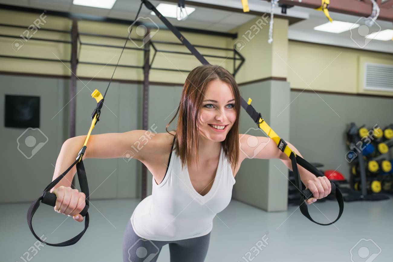 Trx 피트 니스 스트랩과 탄력있는 밧줄 연습을 하 고 체육관에서 젊은 행복 한 여자 보디. 로열티 무료 사진, 그림, 이미지 그리고  스톡포토그래피. Image 90804540