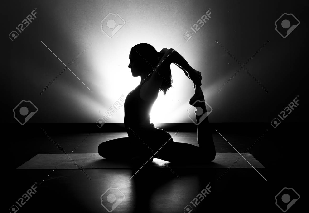 Woman doing yoga pigeon pose silhouette black and white stock photo 72833961
