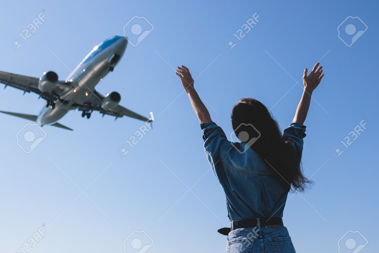 Menina E O Avião Em Voo, Paisagem Com Mulher De Pé Com As Mãos Levantadas,  Acenando Braços E Voando Avião De Passageiros, Turista Do Sexo Feminino E  Pouso Avião Comercial, Dia Ensolarado
