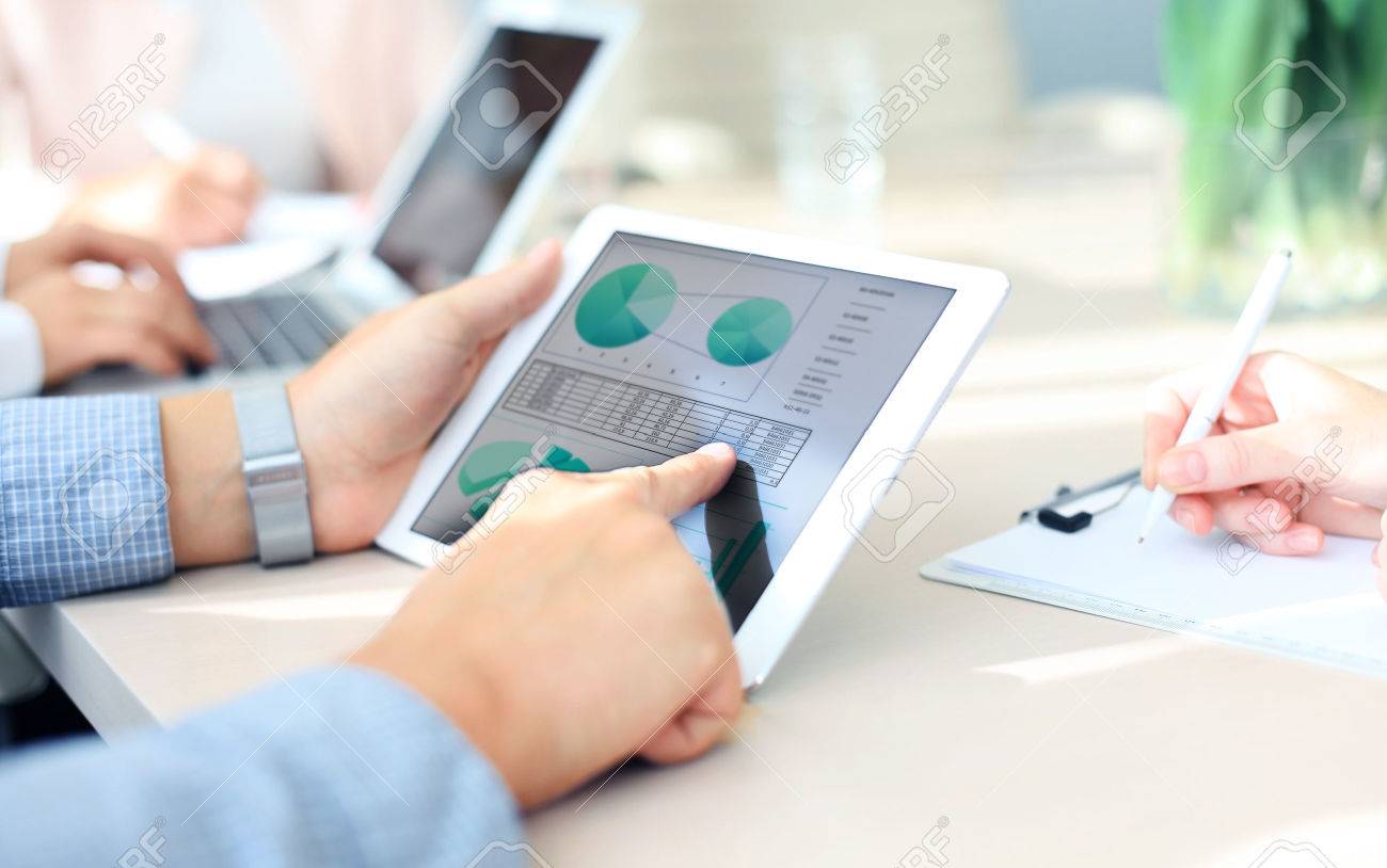 Business person analyzing financial statistics displayed on the tablet screen - 45261590 Business person analyzing financial statistics displayed on the tablet screen - 45261590