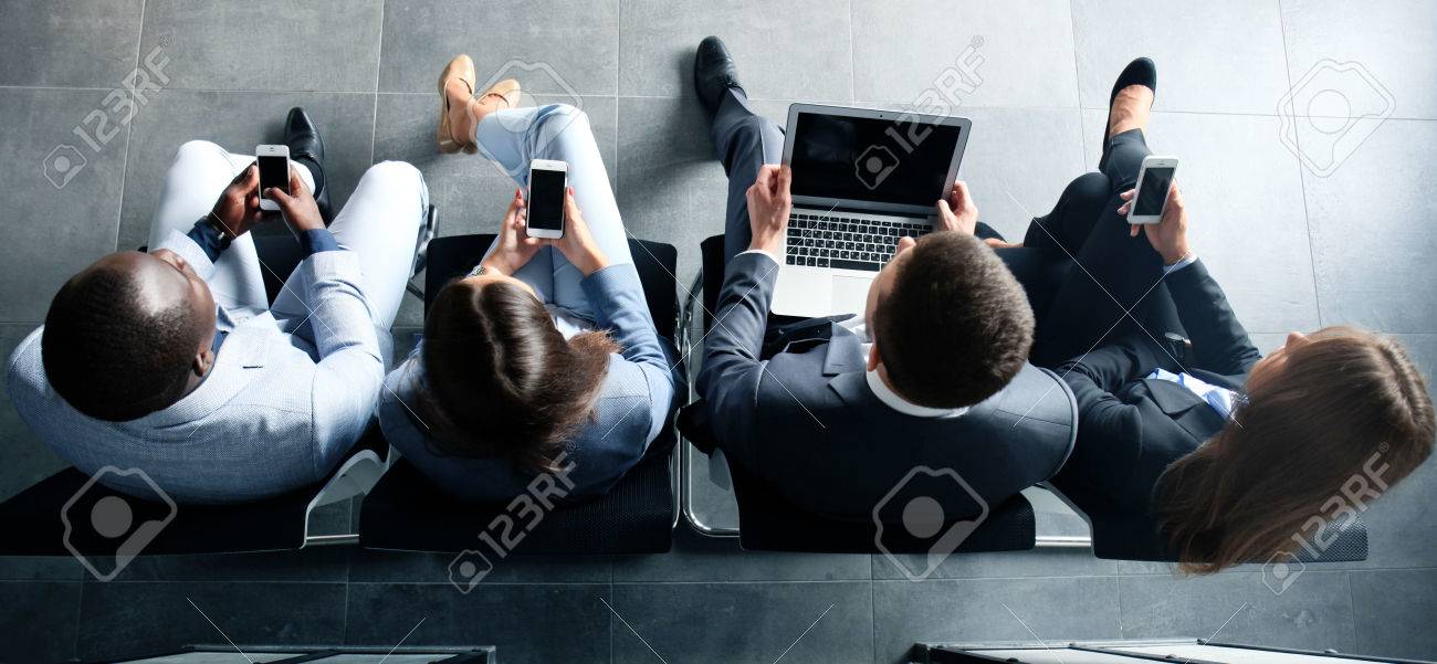 Group of attractive young bussinespeople sitting on the chairs using a laptop, Tablet PC, smart phones, smiling - 62834398 Group of attractive young bussinespeople sitting on the chairs using a laptop, Tablet PC, smart phones, smiling - 62834398