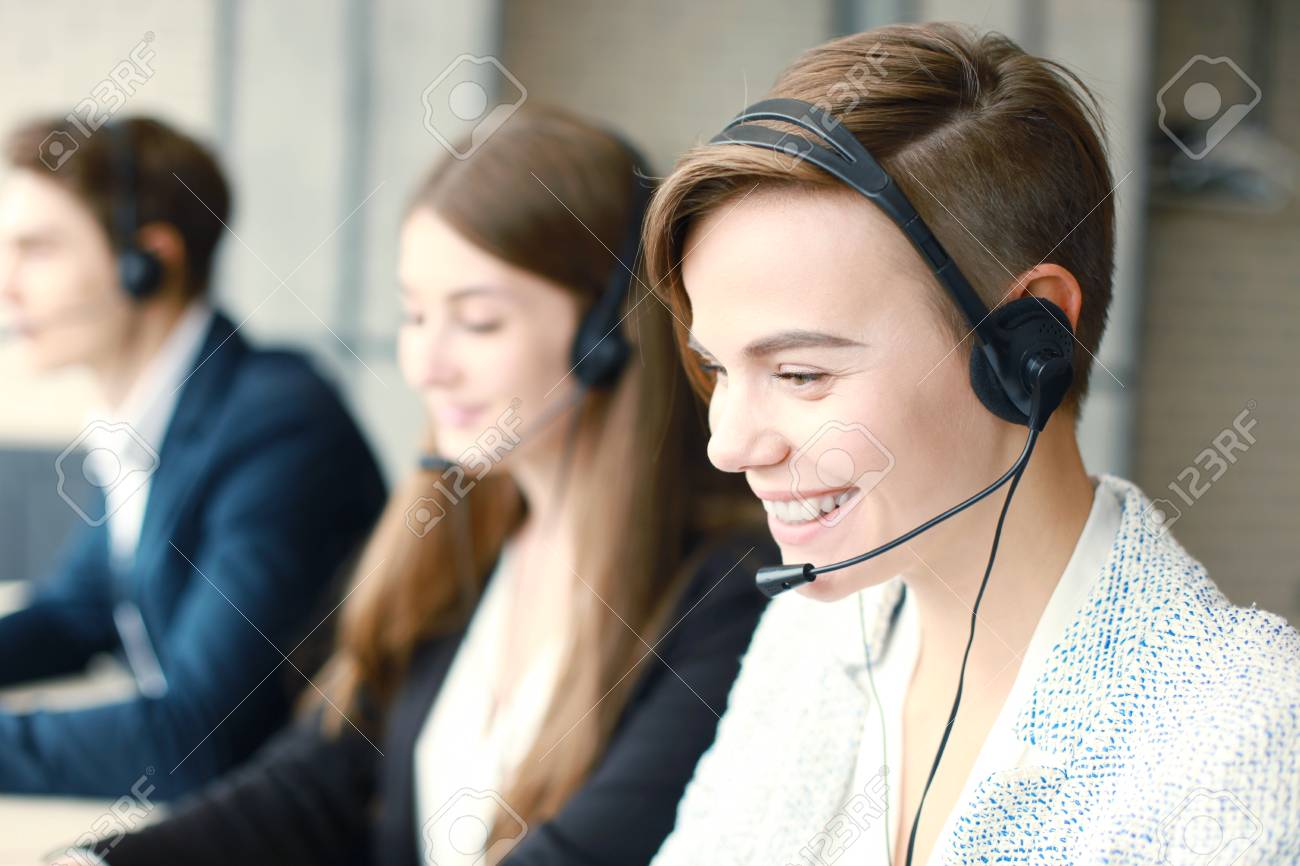Attractive positive young businesspeople and colleagues in a call center office. - 82333603 Attractive positive young businesspeople and colleagues in a call center office. - 82333603